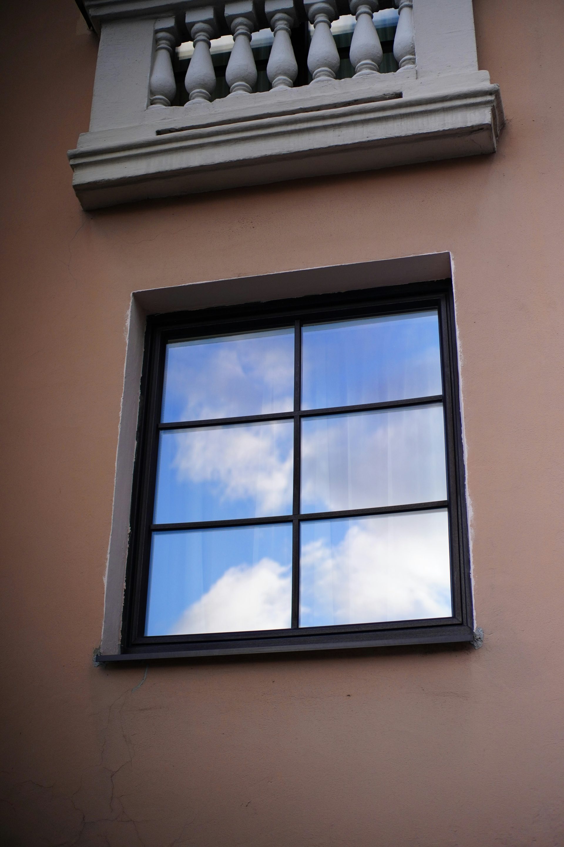 Un edificio alto con una ventana y un cielo al fondo.