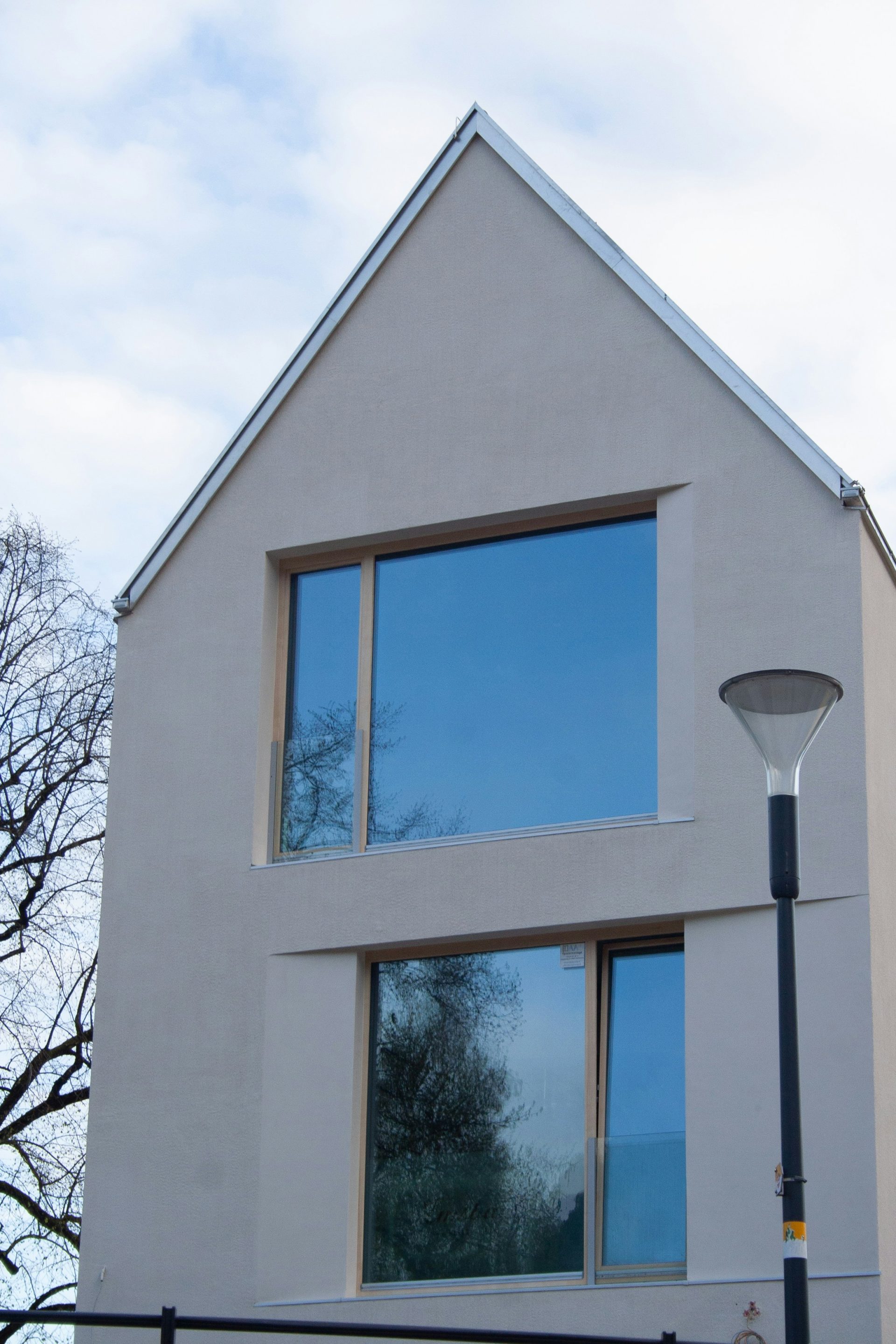 Una casa blanca con una valla negra y una farola.